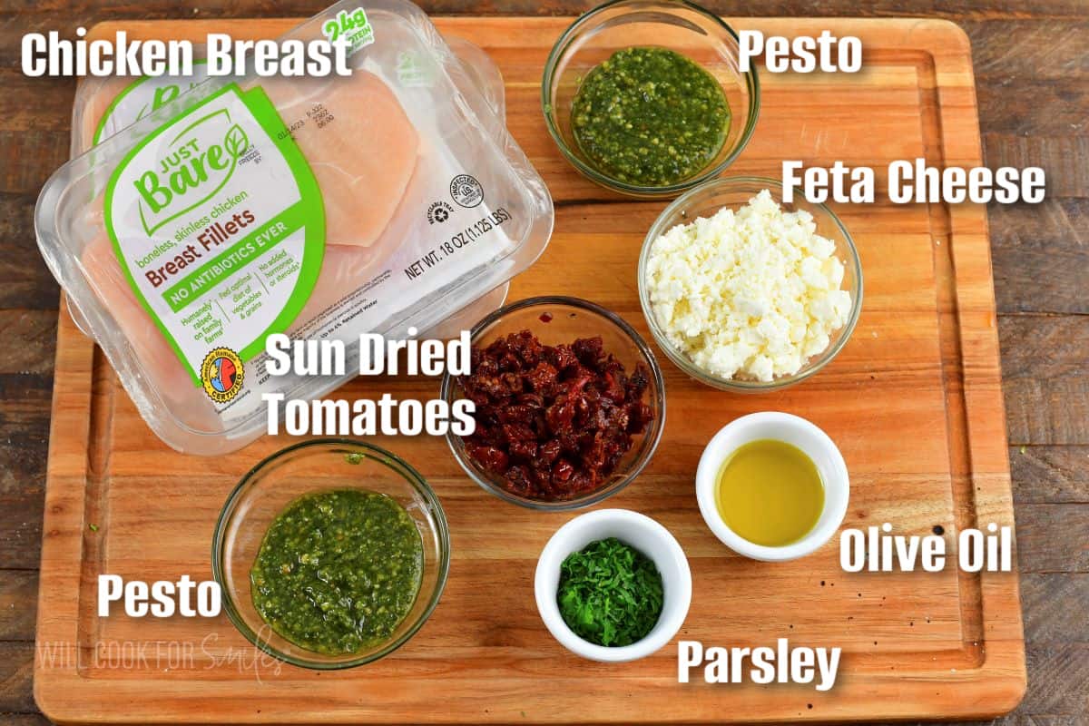 labeled ingredients to make Sun Dried Tomato Feta Stuffed Chicken on cutting board.