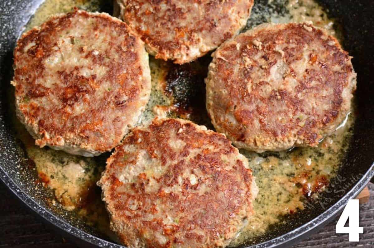 four turkey burgers cooking in the pan.
