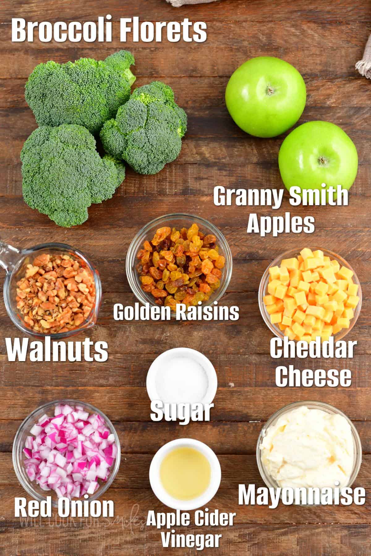 The ingredients for broccoli salad are placed on a wooden surface. 