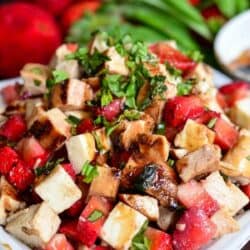 cubed chicken, mozzarella, and strawberries balsamic salad in a white bowl.