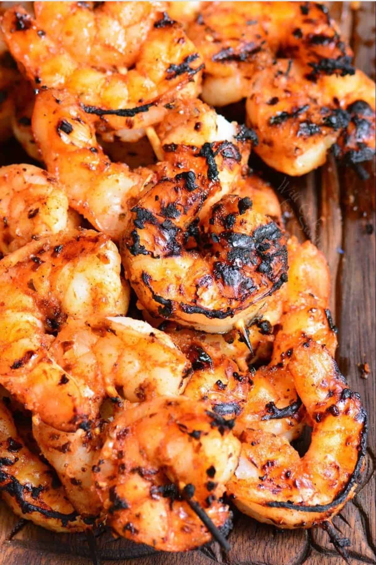grilled shrimp on skewers are placed in a small pile 