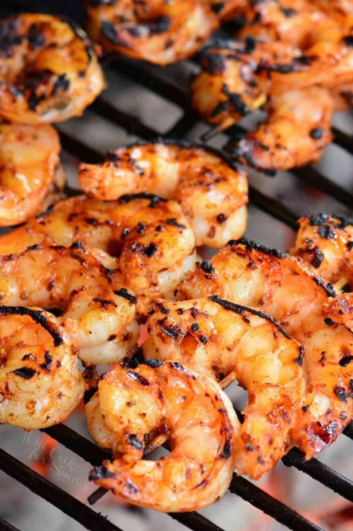 skewered Cajun shrimp grilling on the grill grate.