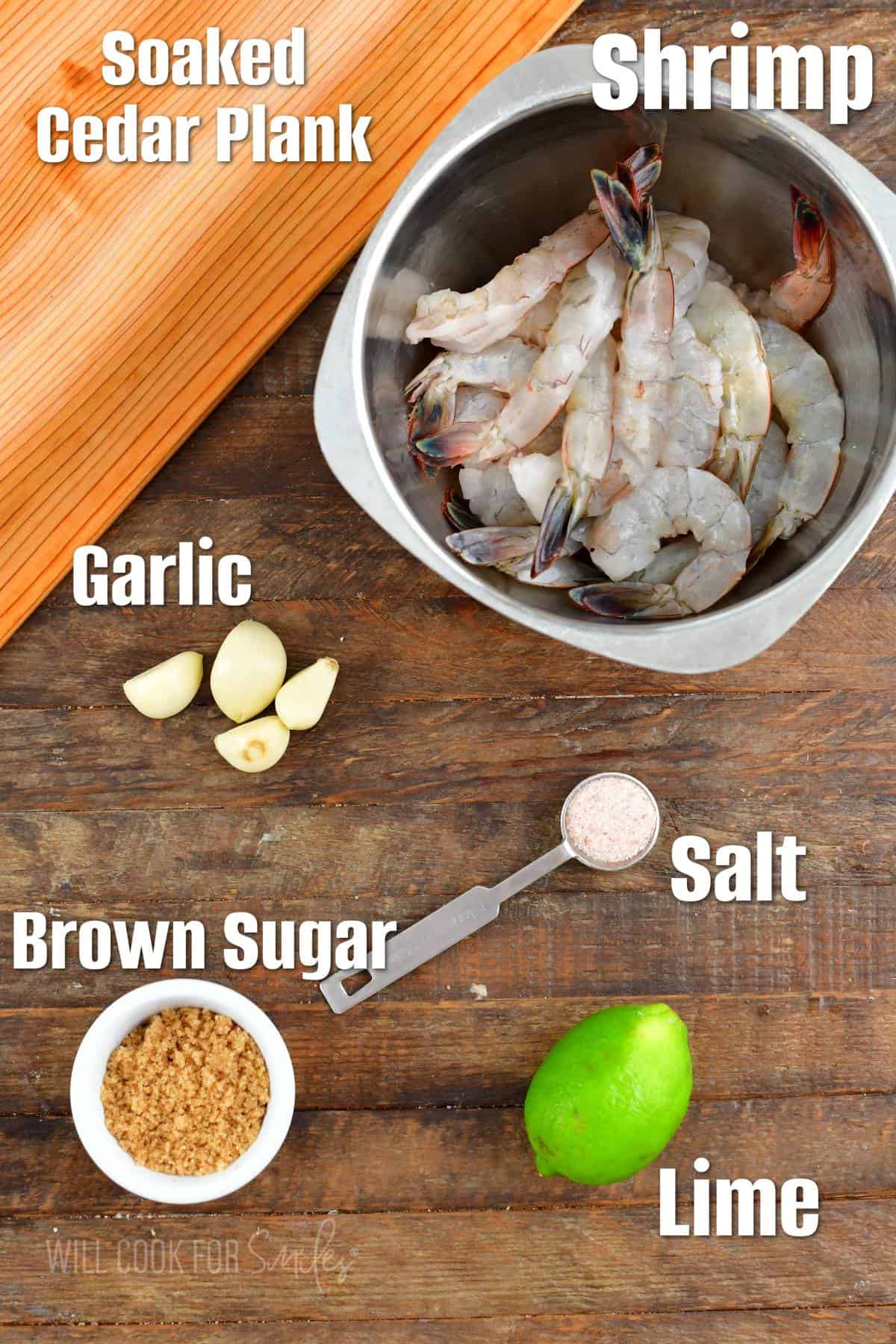 The ingredients for cedar plank shrimp are placed on a wooden surface. 