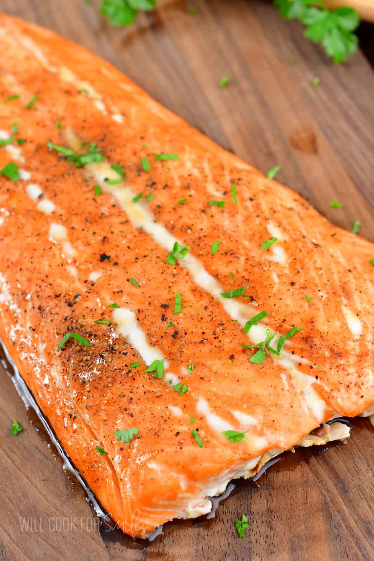 Fresh herbs are spread across the top of a salmon filet. 