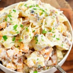 starting to scoop some creamy tortellini salad out of the bowl.