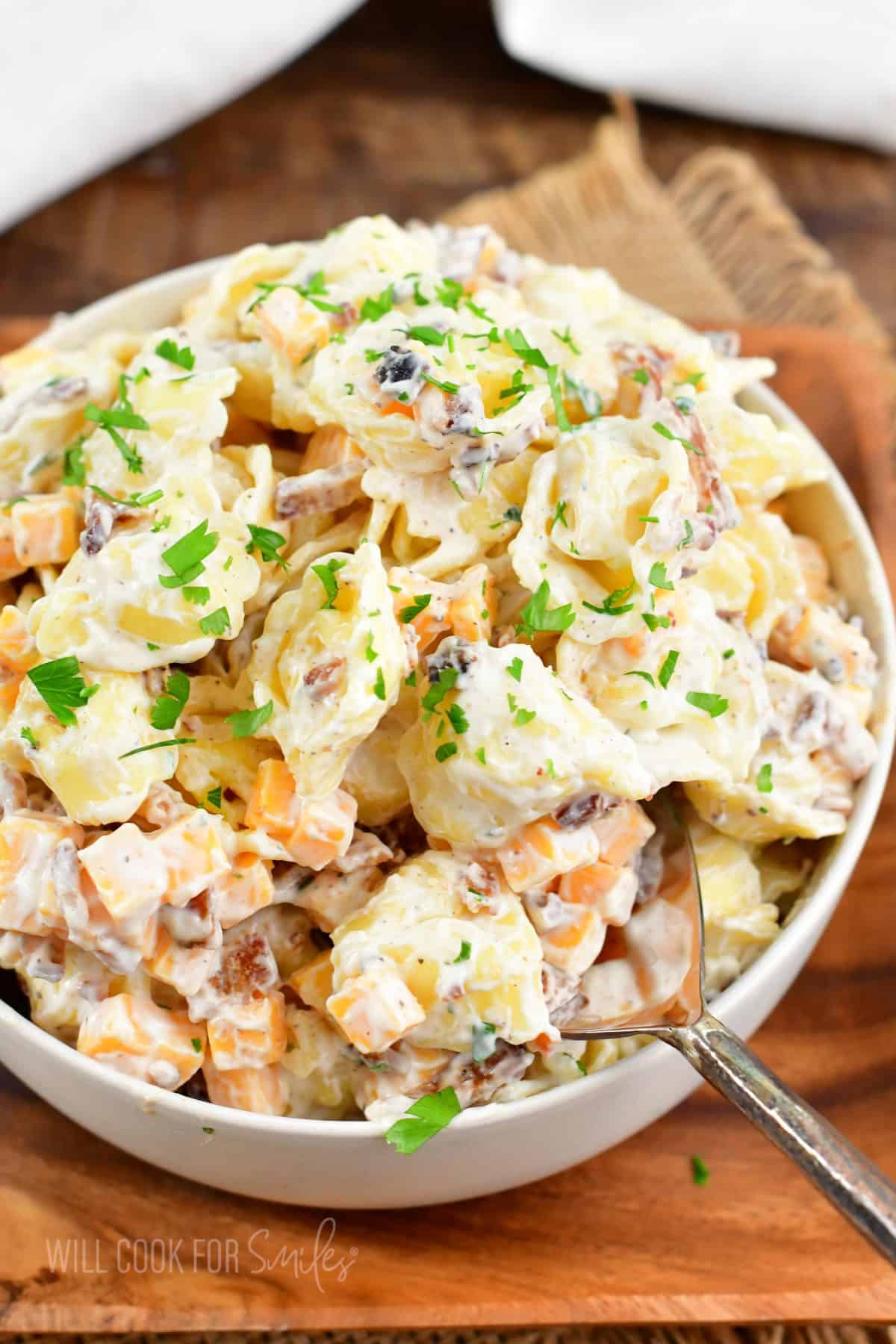 fresh herbs garnish a large serving of pasta salad