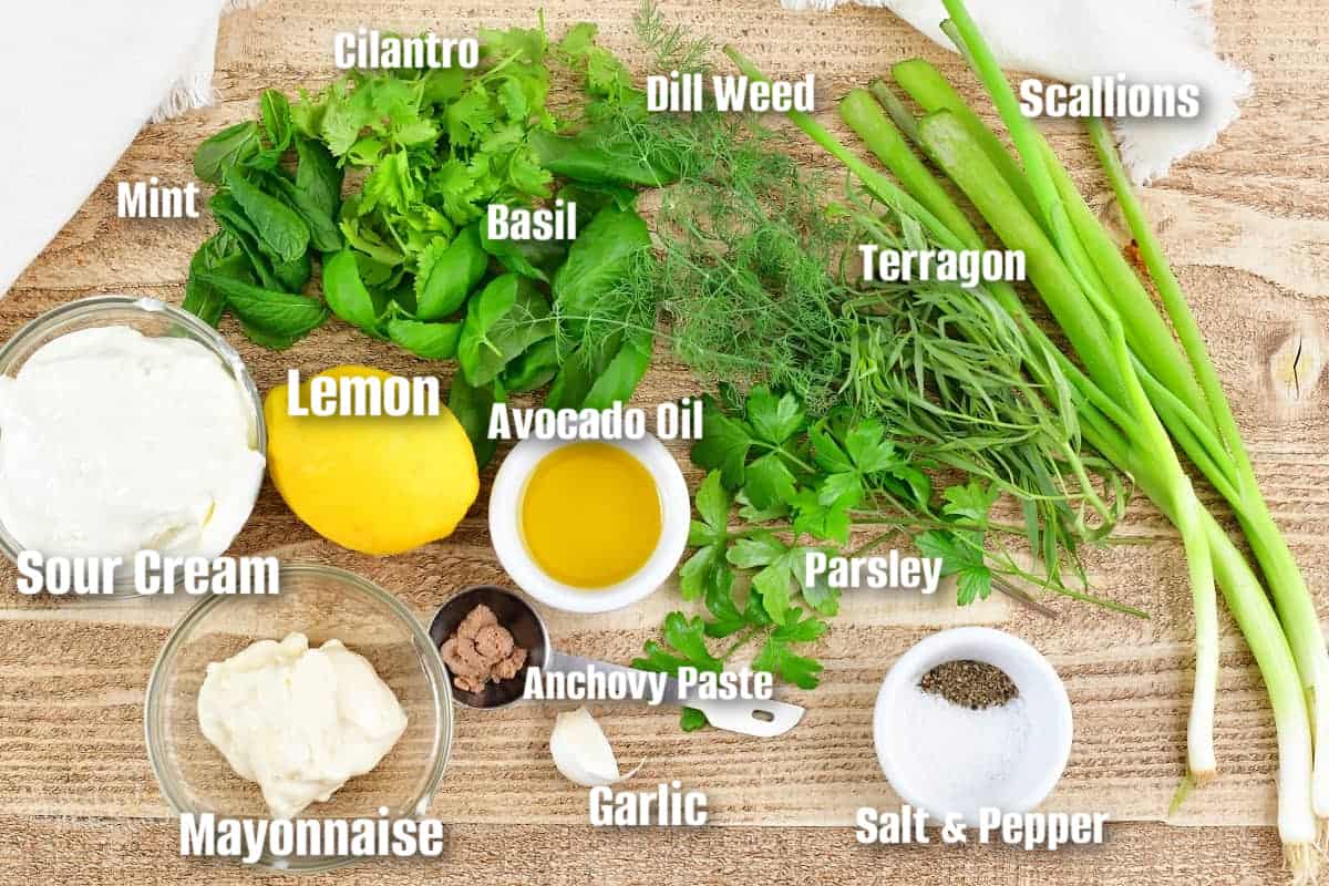labeled ingredients to make green goddess dressing on light wooden board.