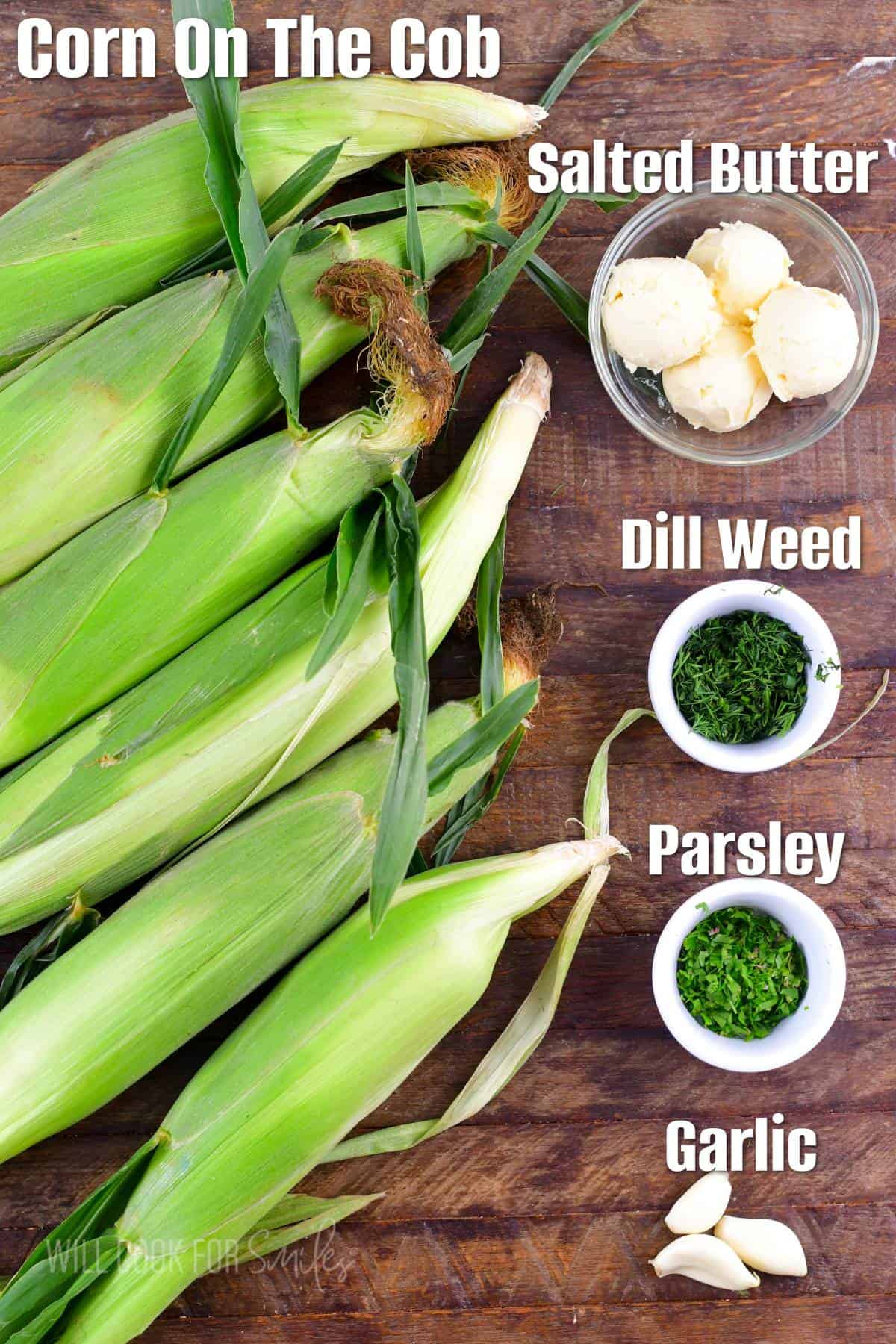 labeled ingredients to make grilled corn on the cob with garlic butter on wooden board.