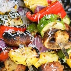 several skewers of grilled Italian mixed vegetables with shaved parmesan.