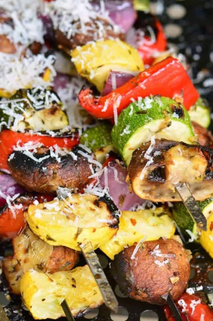 several skewers of grilled Italian mixed vegetables with shaved parmesan.