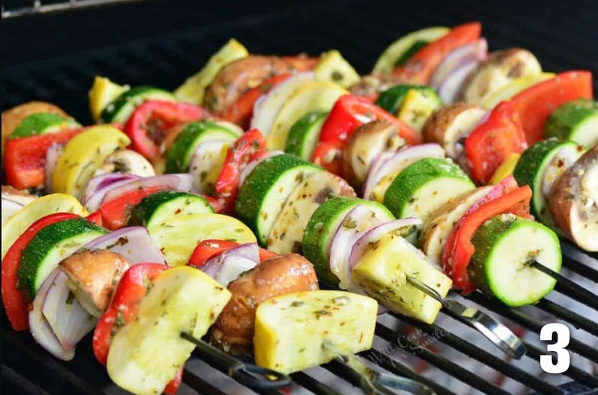 Vegetable skewers are being cooked on a grill. 