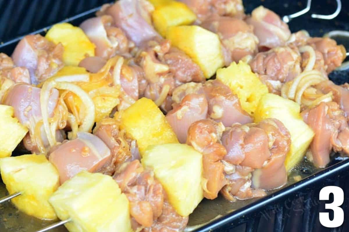 uncooked pineapple chicken skewers are placed on the grill 