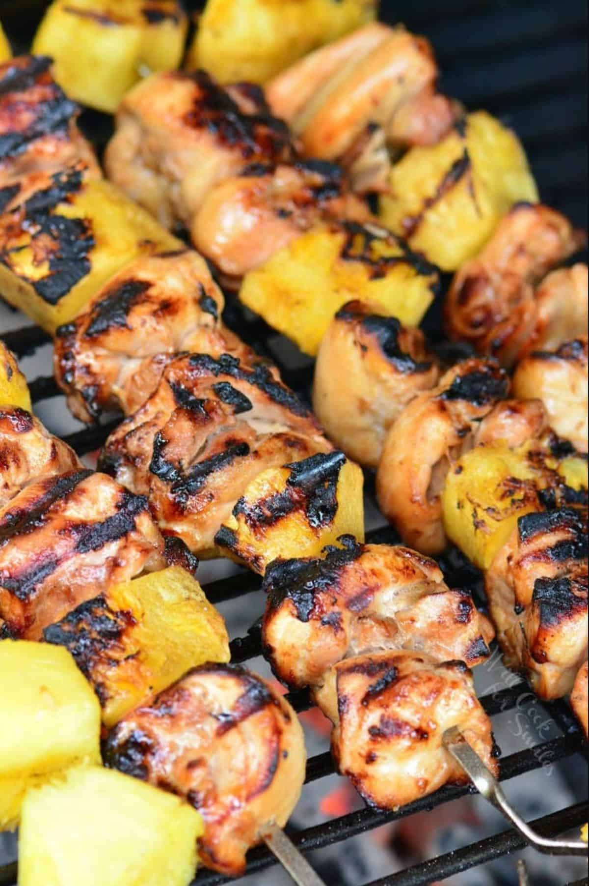 several grilled chicken and pineapple kebobs are on the grill