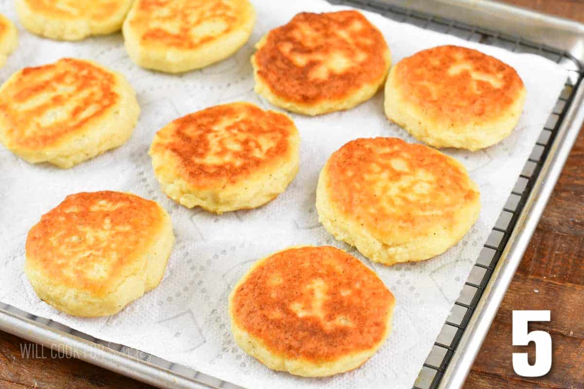 several cooked mashed potato cakes on a paper towel and cooling rack.