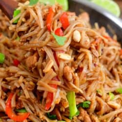 holding a large serving of the rice noodles on a spoon over the pan.