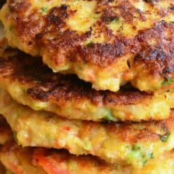 a stack of five shrimp burgers on parchment paper up close.