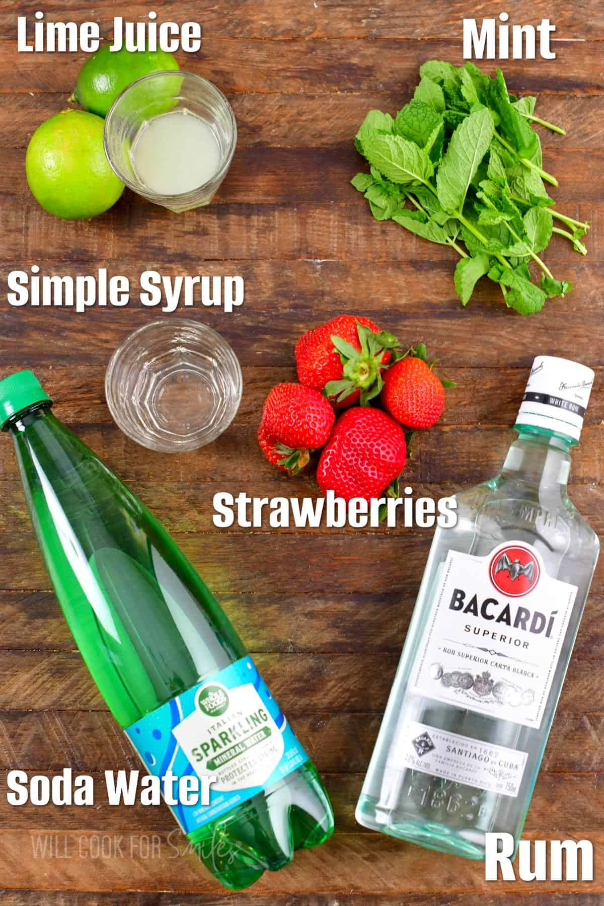 The ingredients for strawberry mojito are placed on a wooden surface. 