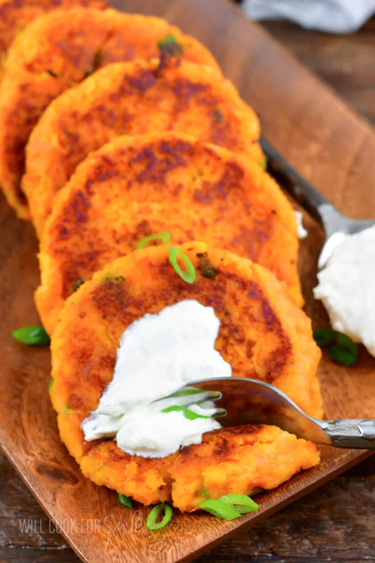 A fork is digging into a sour cream topped sweet potato cake. 