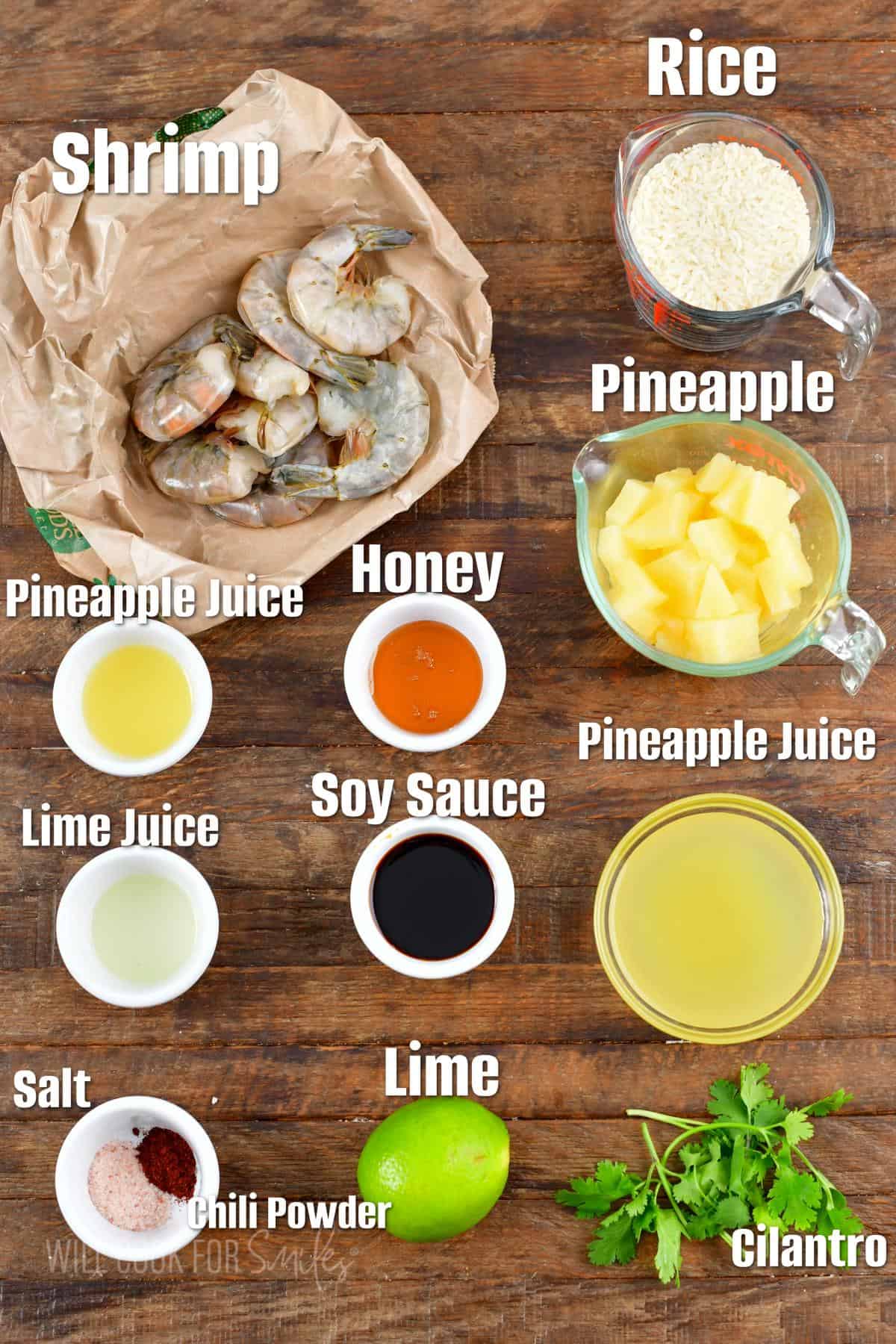 The ingredients for tropical shrimp rice bowl are placed on a wooden surface. 