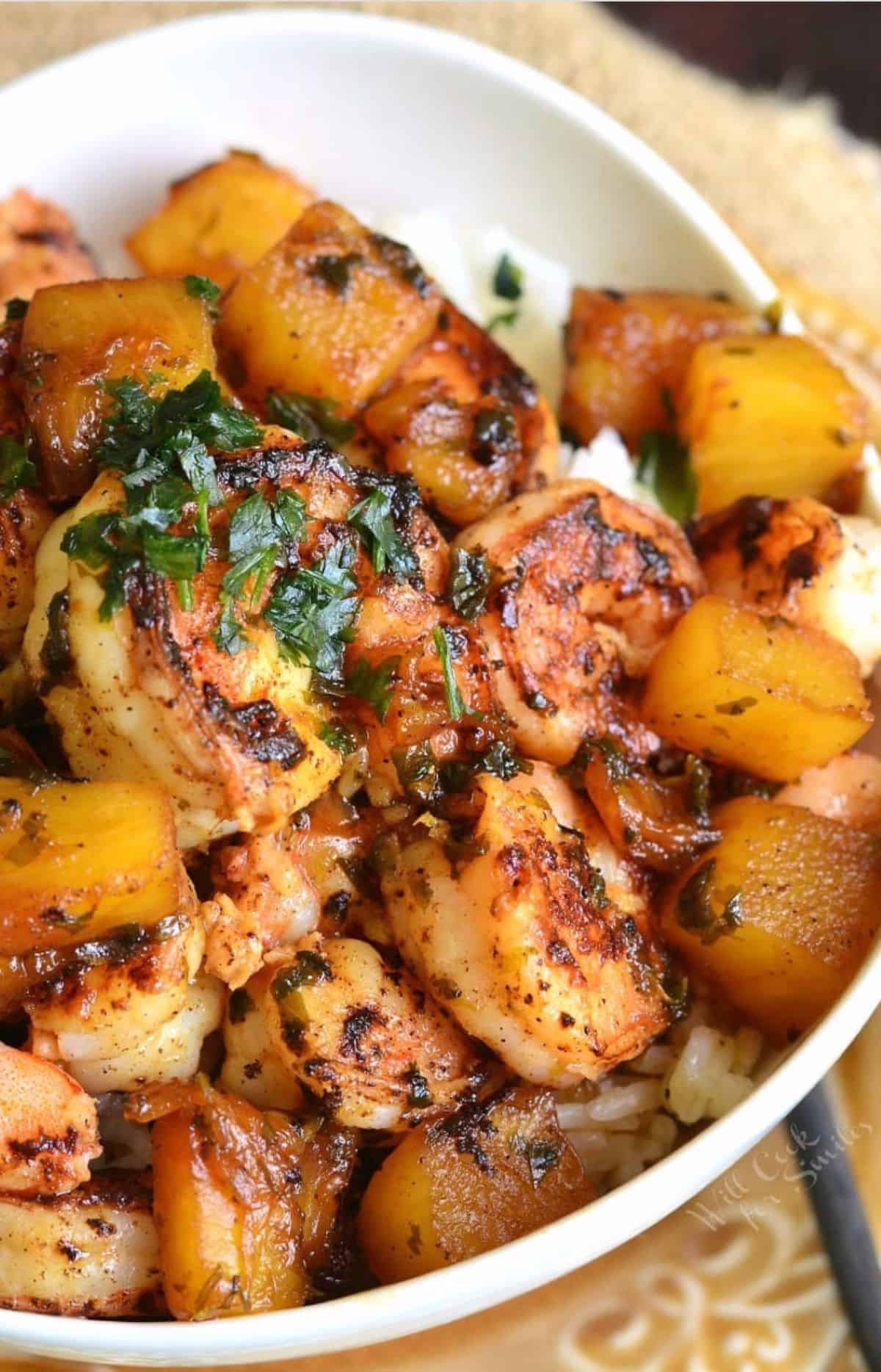 Cilantro garnishes a tropical shrimp rice bowl. 