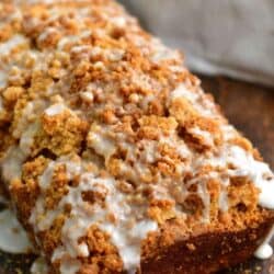 baked zucchini bread with streusel on top and white icing drizzled.