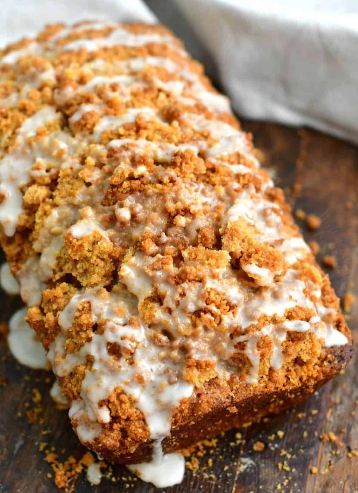 baked zucchini bread with streusel topping and icing on top. 