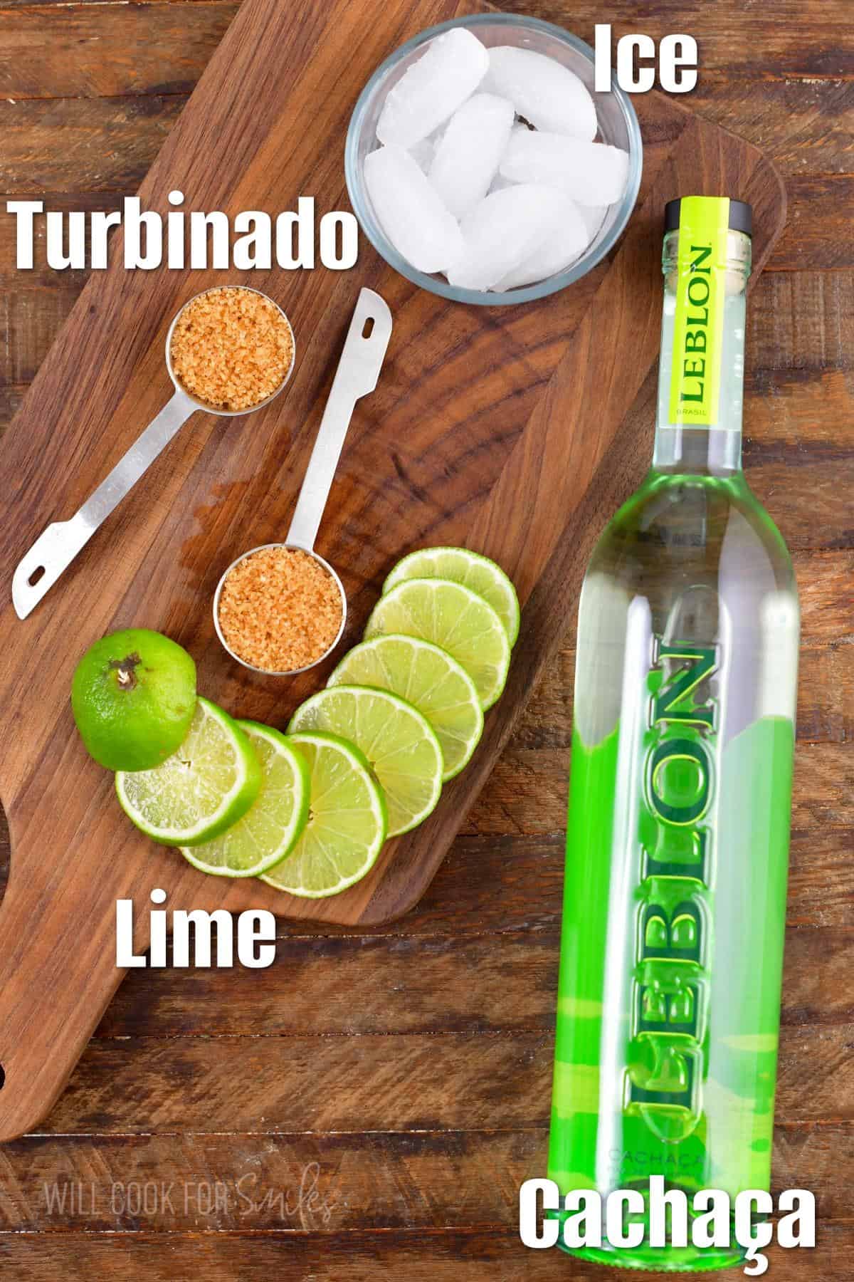 The ingredients for Caipirinha labeled and placed on a wooden surface.
