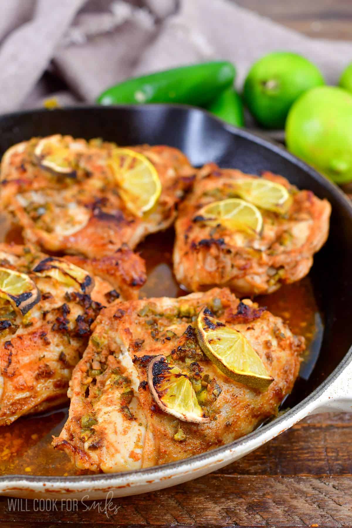 Cooked chicken breasts are placed in a skillet. 