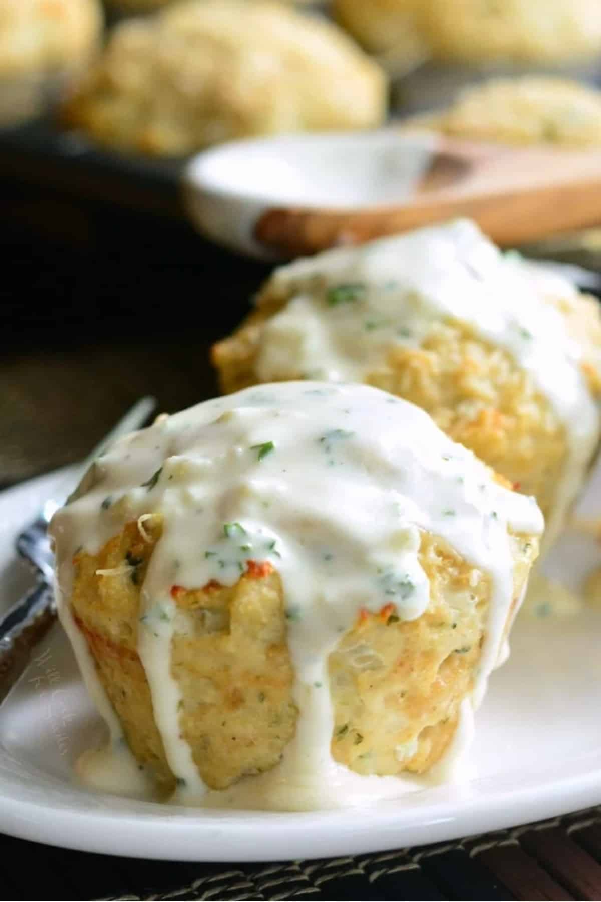 White parmesan sauce coats an individual chicken meatloaf. 