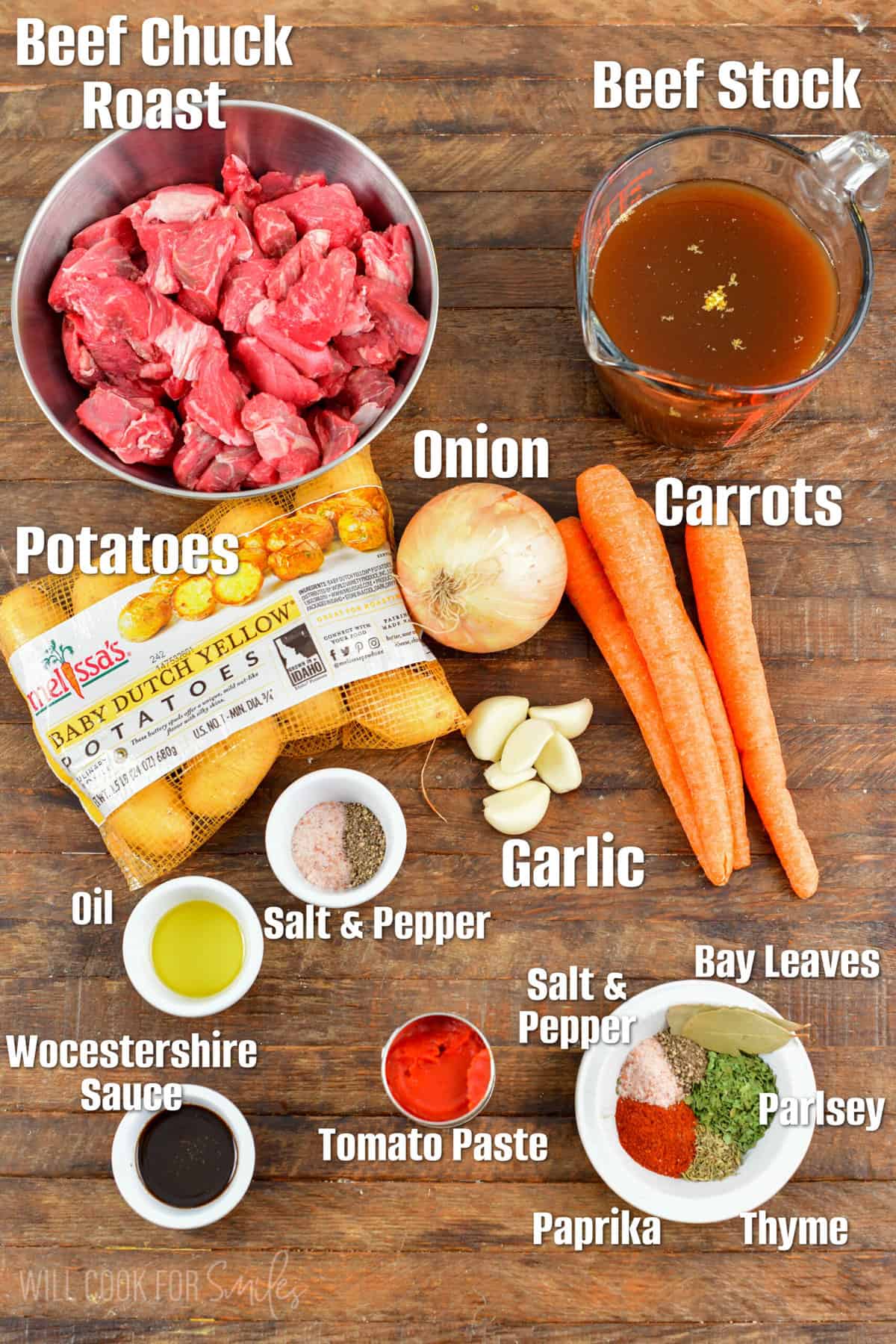 Labeled ingredients for beef stew on a wood surface.