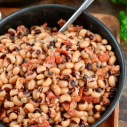 black eyed peas in a bowl with a fork in it on a wood surface.