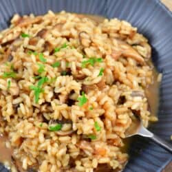 mushroom risotto in a bowl with a fork scooping some up.