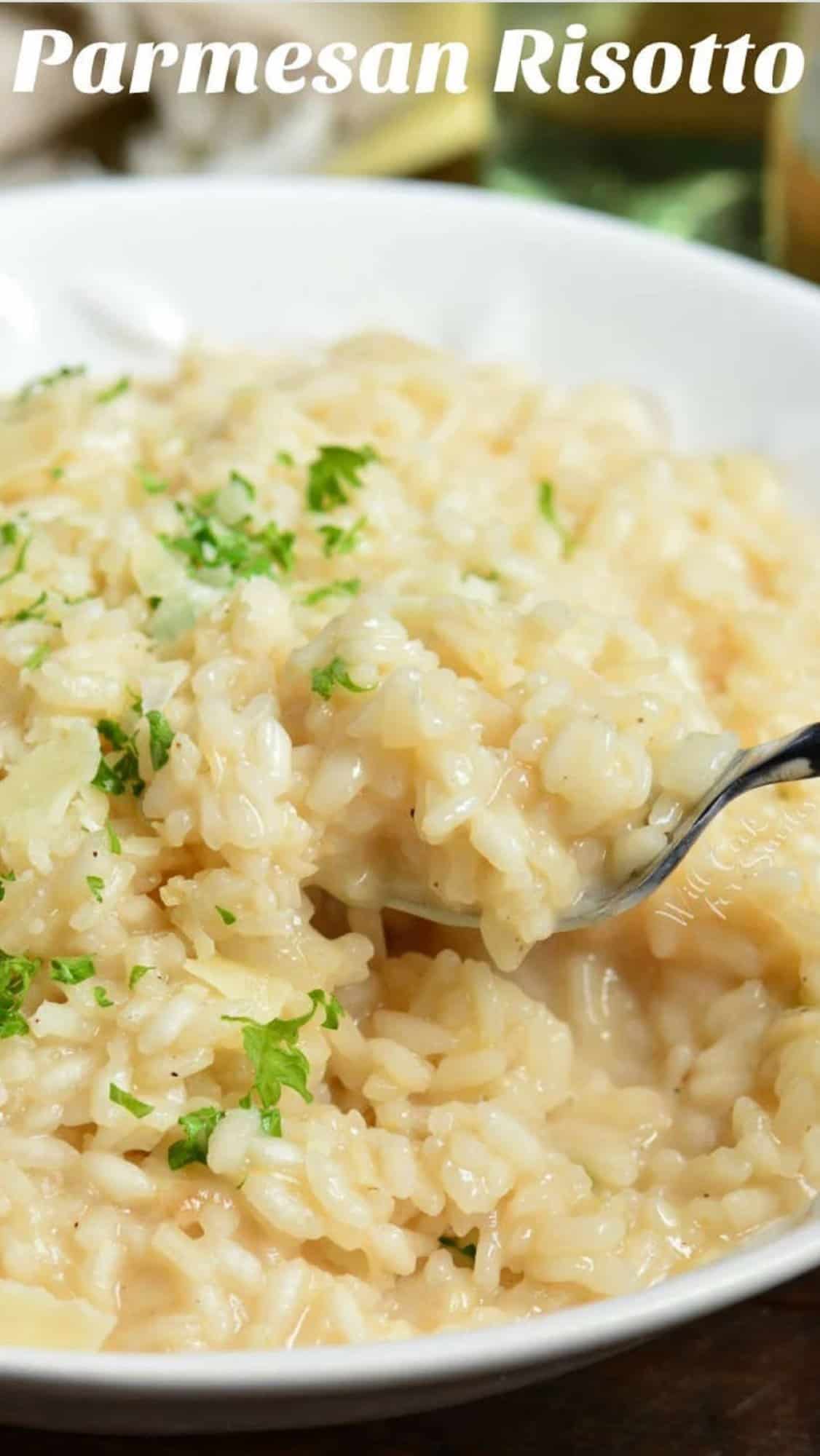 parmesan risotto in a bowl with a fork scooping some up.
