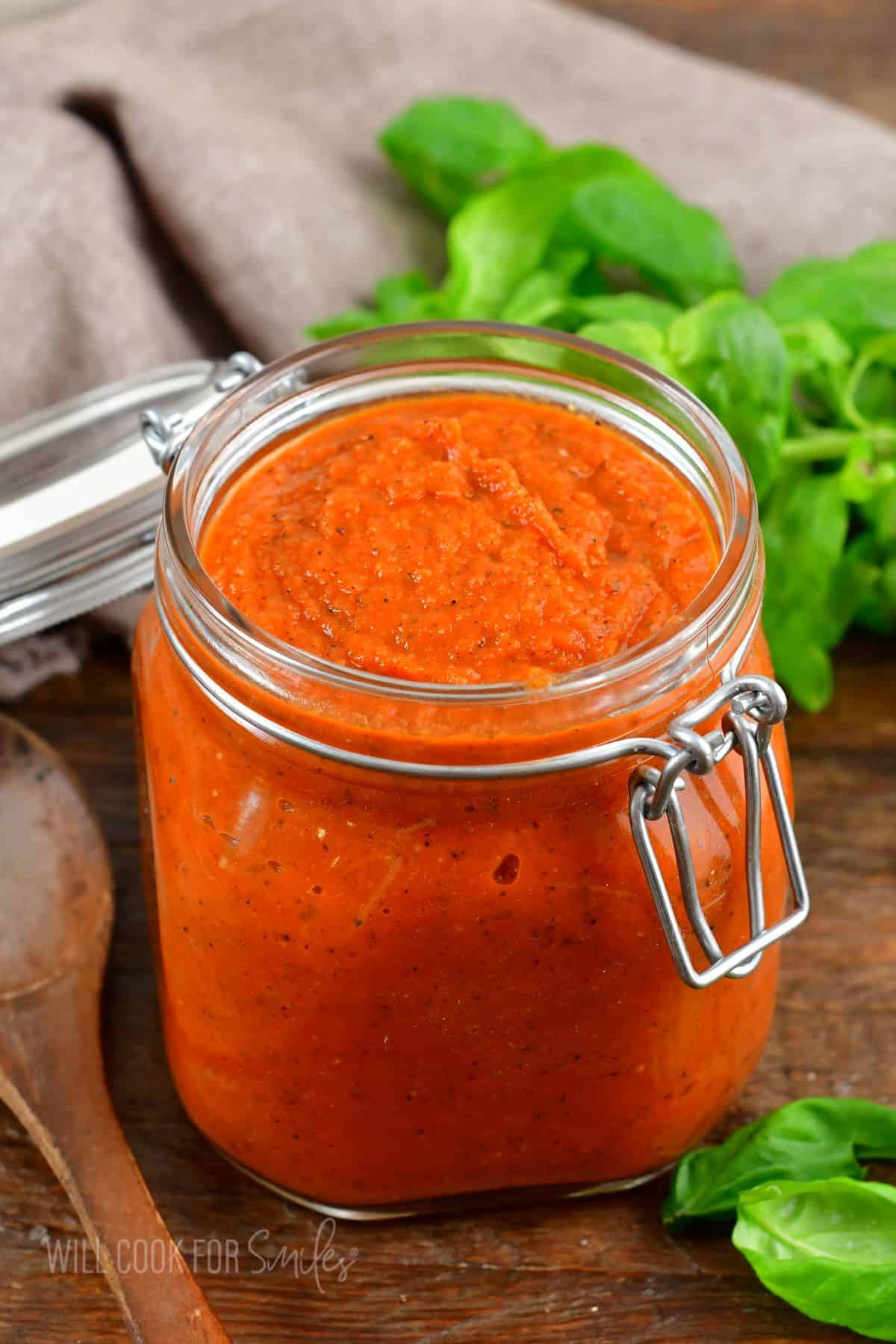 spaghetti sauce in a glass jar on a wooden surface.