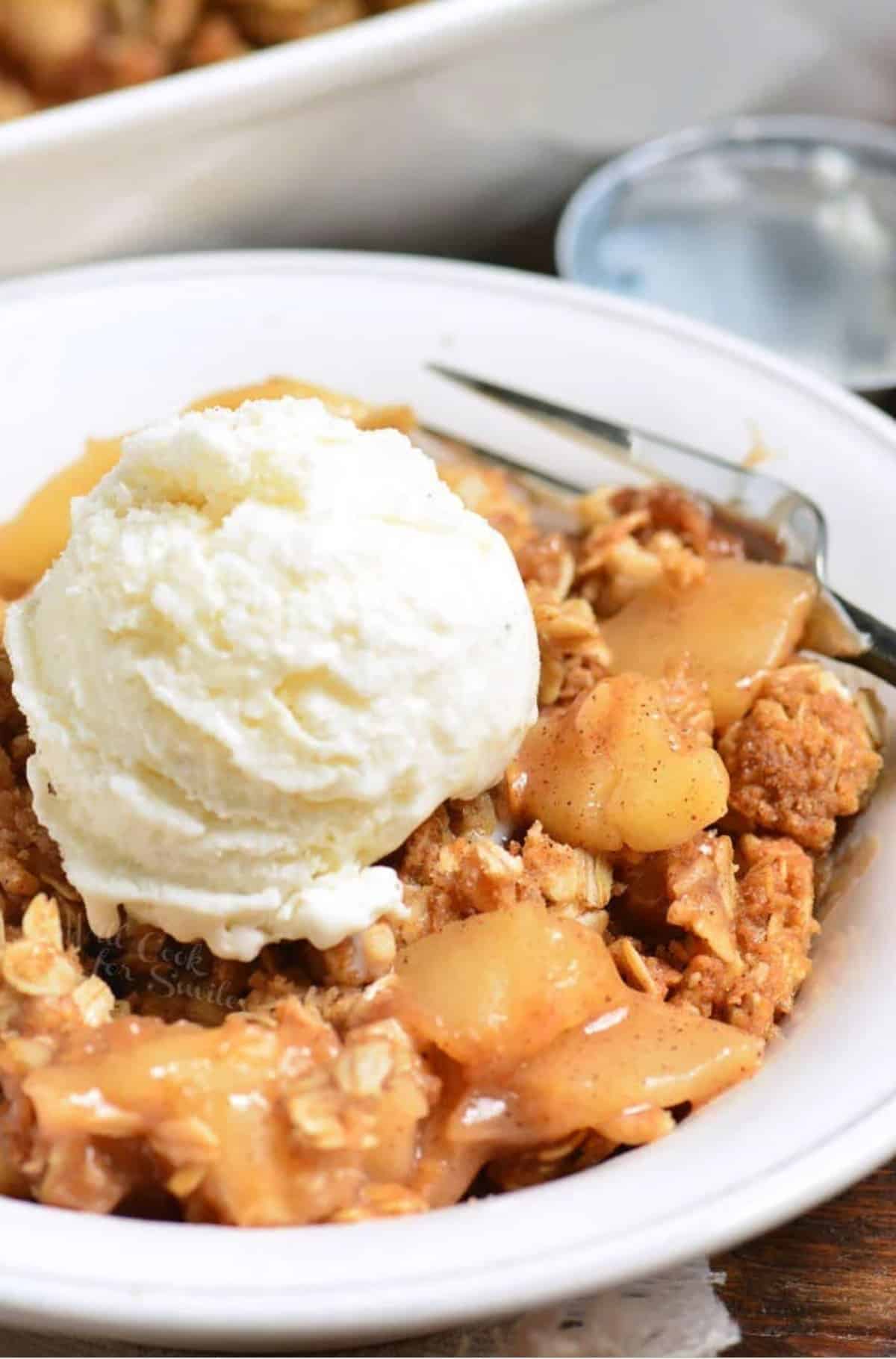 Apple Crisp in a bowl with ice cream on top.