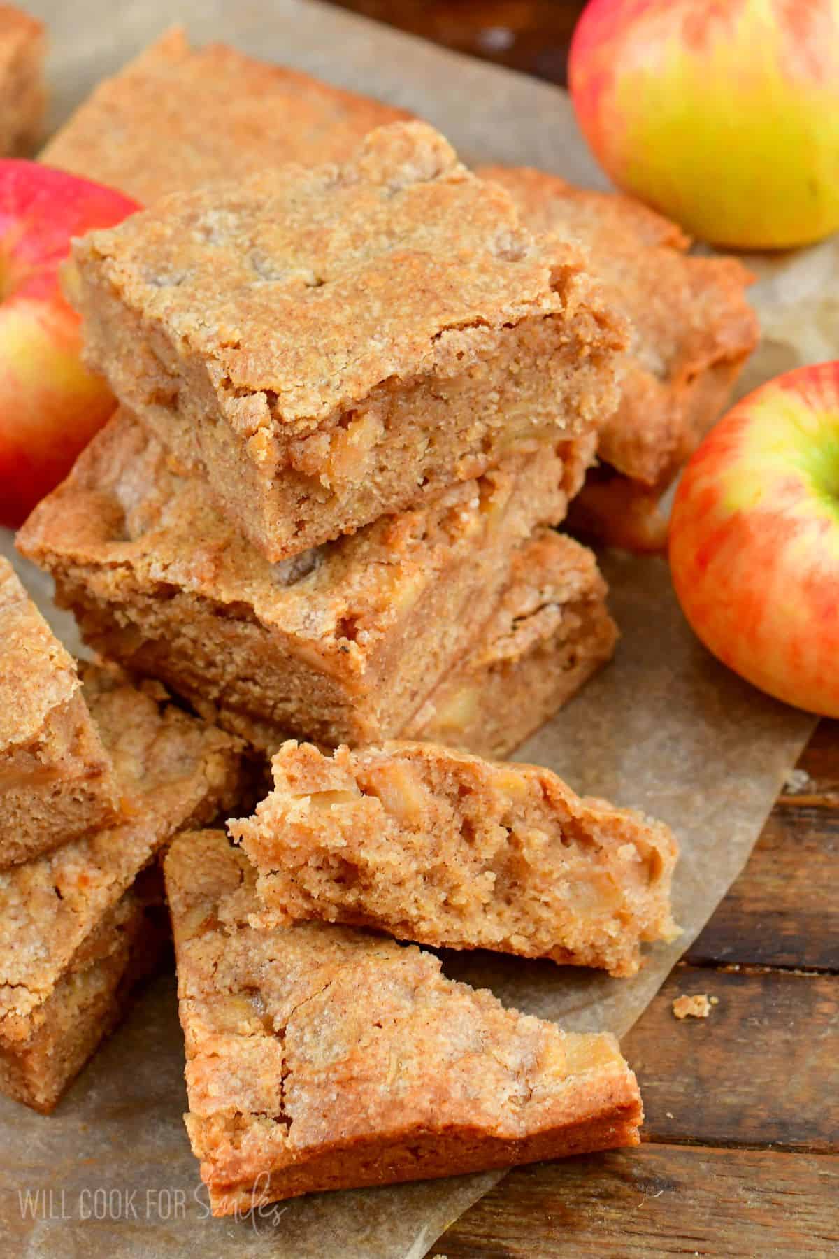 Apple pir blondies stacked up with one broken in half on wax paper.