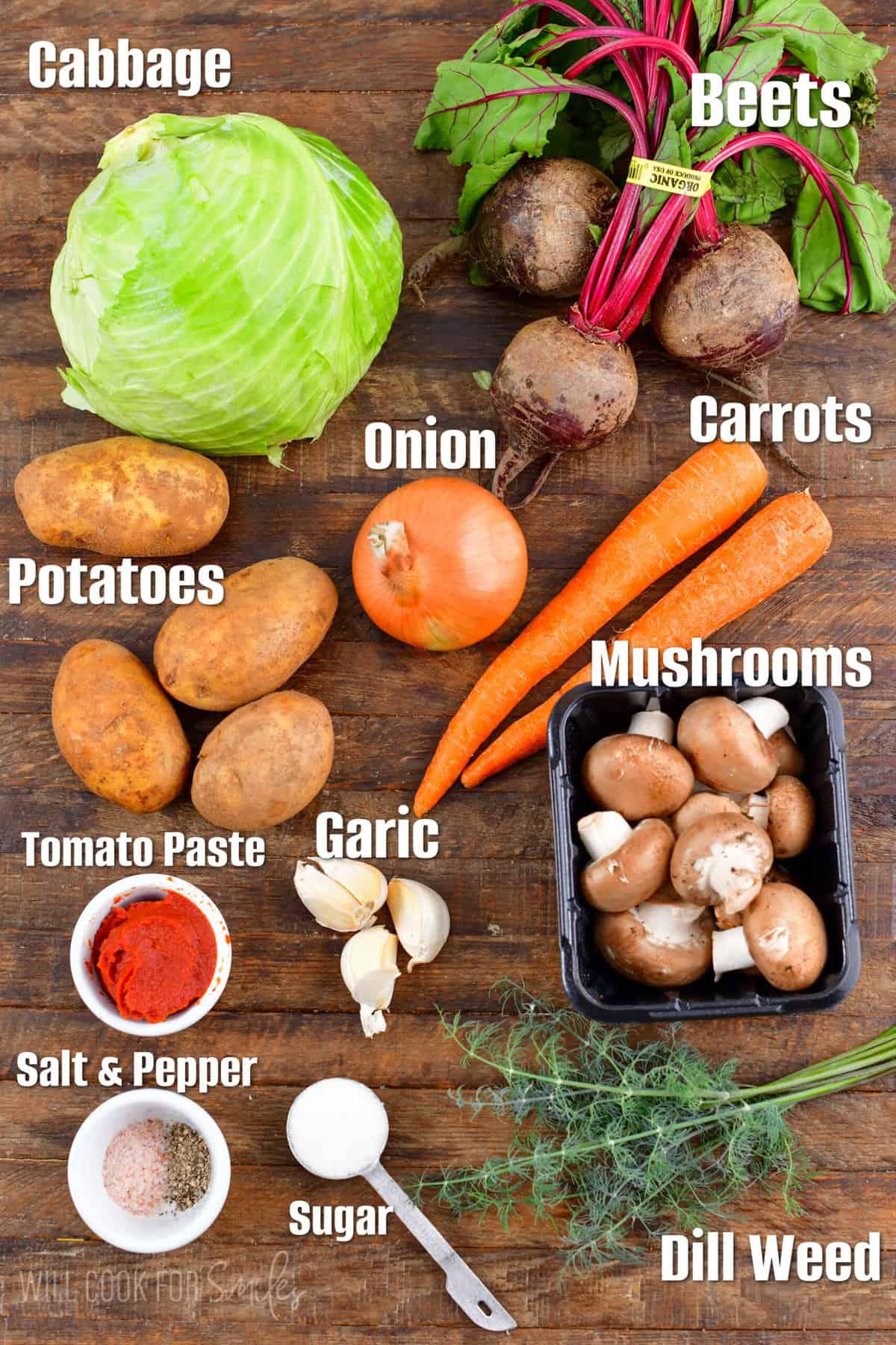 Labeled ingredients for borscht soup on a wood surface.