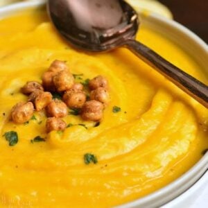 butternut squash in a bowl with chickpeas on and a spoon across the bowl.