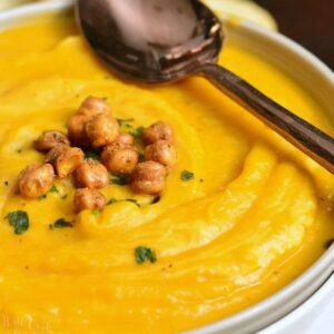 butternut squash in a bowl with chickpeas on and a spoon across the bowl.