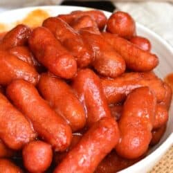 BBQ little smokies in a bowl on a wicker placemat.