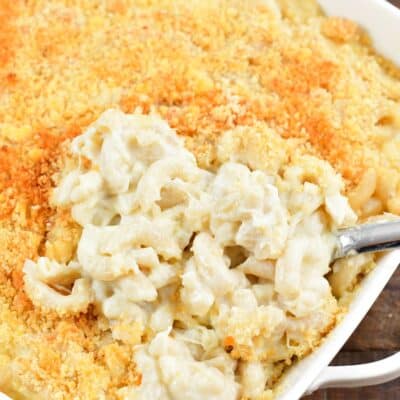 Crab mac and cheese in a baking dish with a scoop taken out.