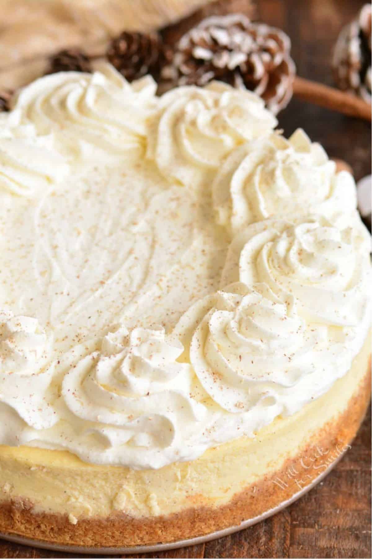Eggnog Cheesecake with topping on a wood surface.