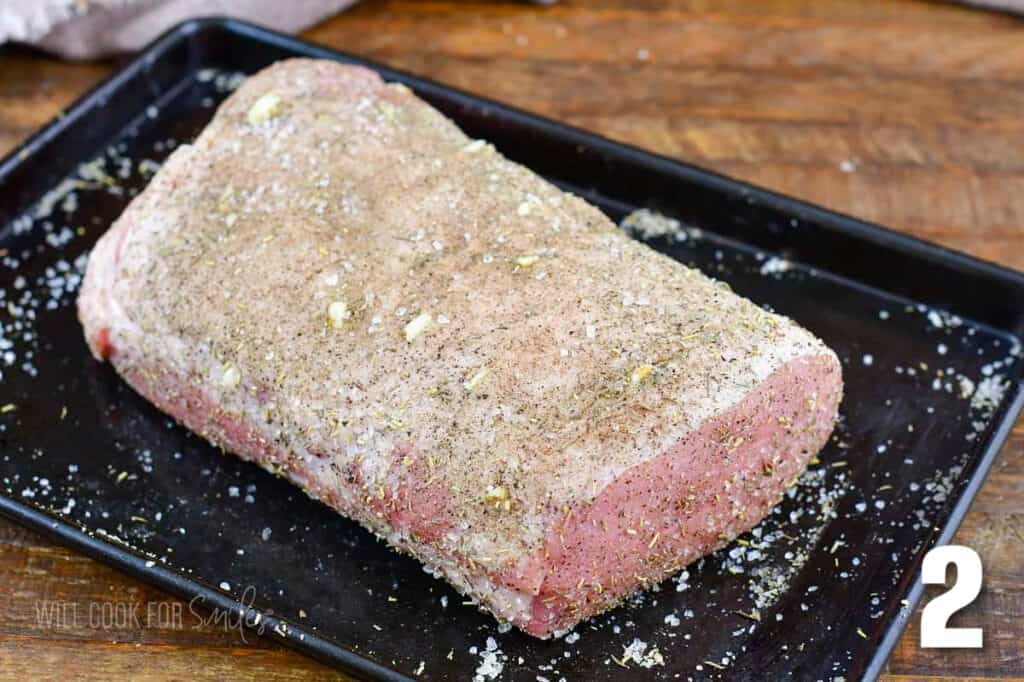 seasoned uncooked pork loin on the baking sheet.