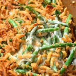 green bean casserole in a baking dish with spoon sitting in the dish.