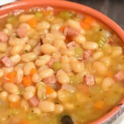 ham and bean soup in a bowl with a spoon scooping some out.