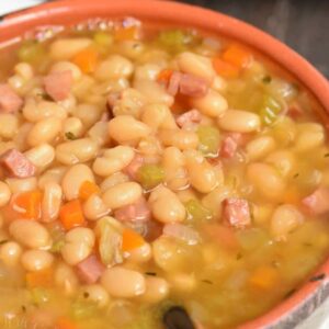 ham and bean soup in a bowl with a spoon scooping some out.