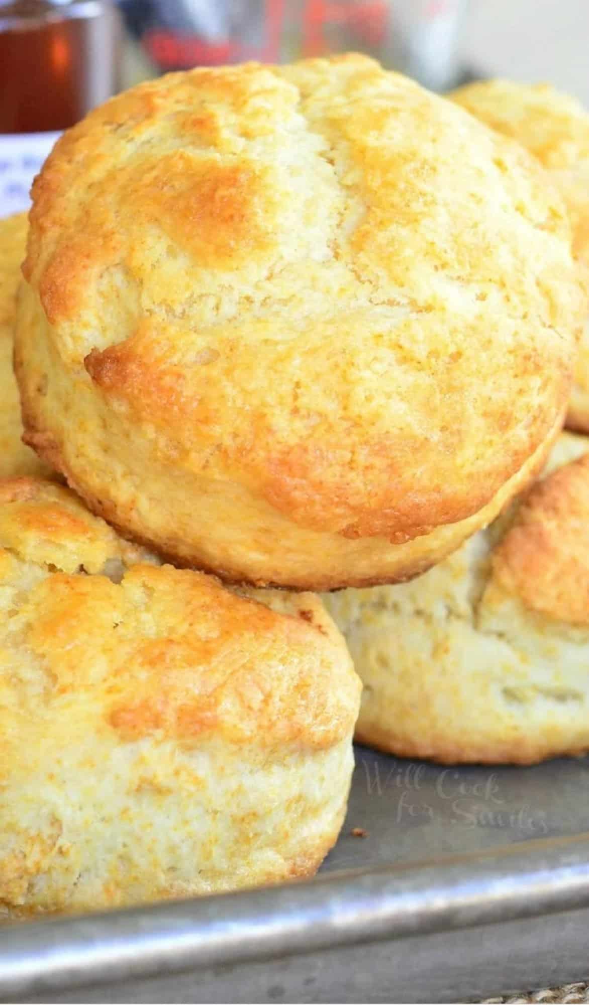 honey butter biscuits stacked on a baking sheet.