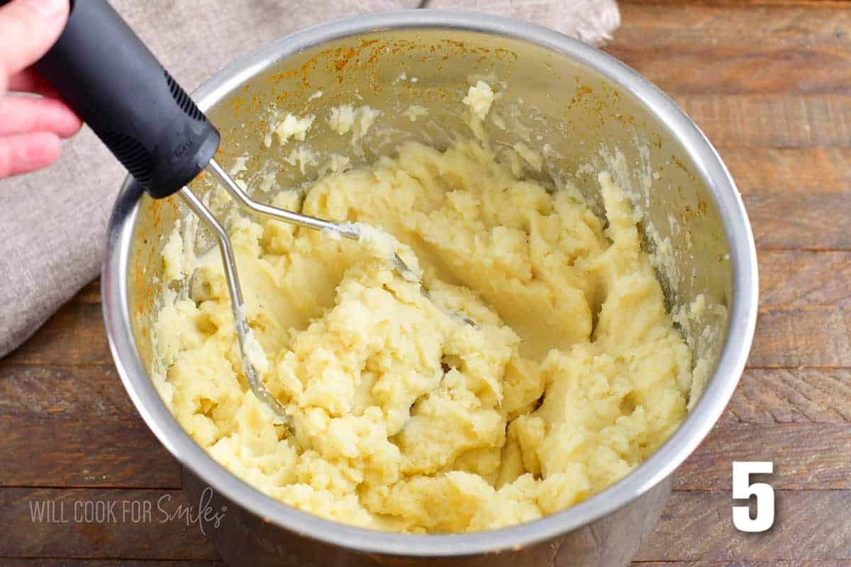 mashing potatoes in an instant pot inside bowl.