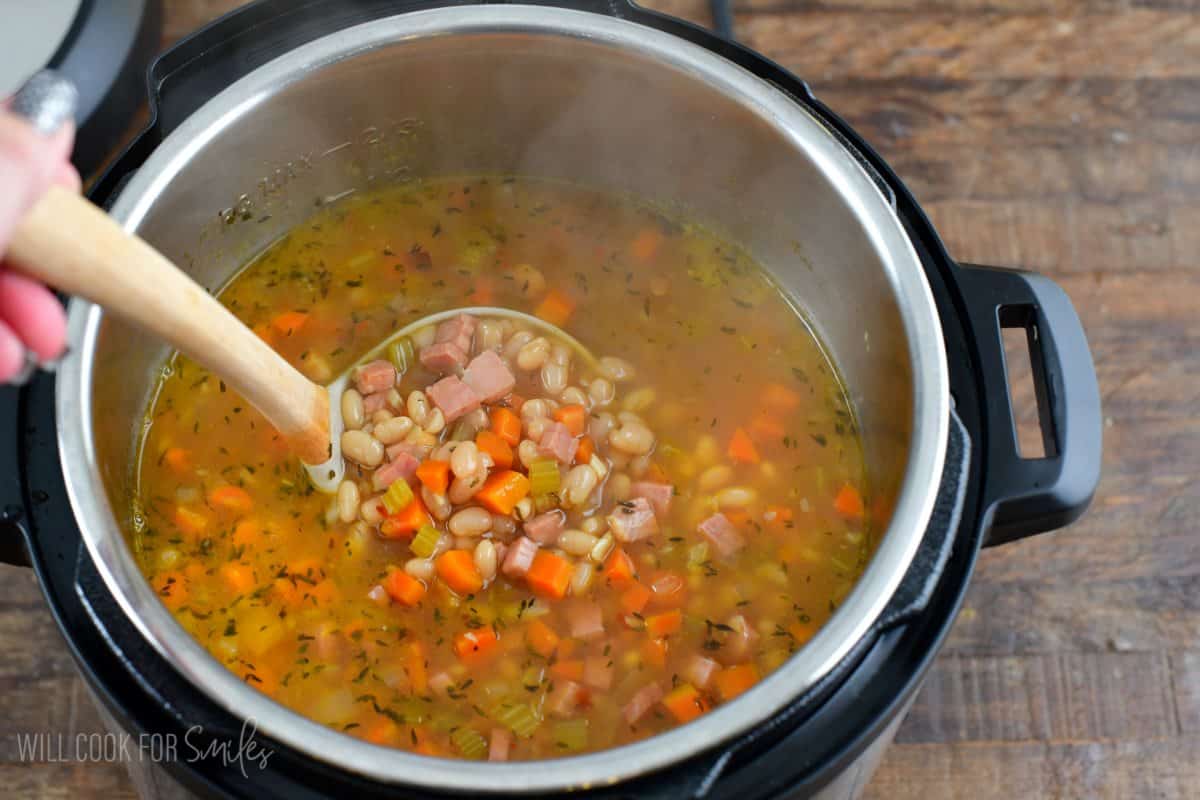 instant pot ham and ben soup with a ladle scooping some up.