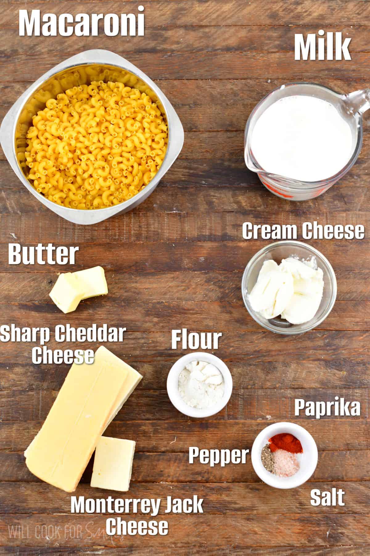 labeled ingredients to make mac and cheese on wooden board.